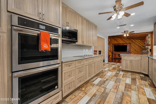894 Quarters Ct, Port Orange, FL 32129 - kitchen featuring appliances with stainless steel finishes, ceiling fan, light countertops, light brown cabinetry, and wooden walls
