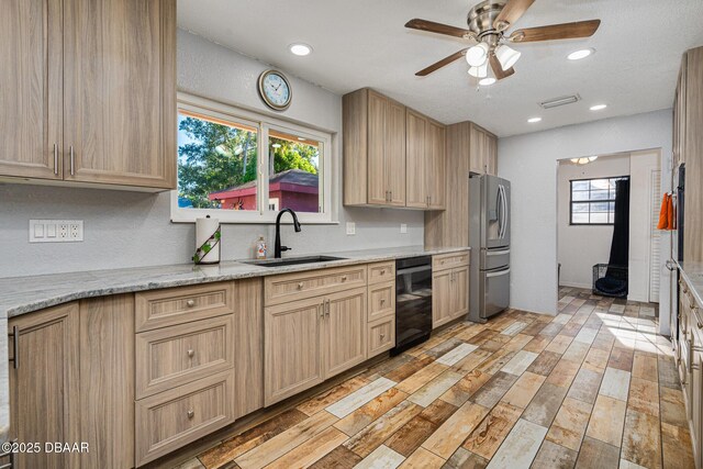 894 Quarters Ct, Port Orange, FL 32129 - kitchen with black dishwasher, stainless steel fridge, light brown cabinetry, ceiling fan, and light wood-style flooring