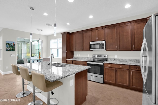 281 Compass Rose Dr, Daytona Beach, FL 32124 - kitchen featuring appliances with stainless steel finishes, a sink, light tile patterned flooring, a kitchen breakfast bar, and pendant lighting