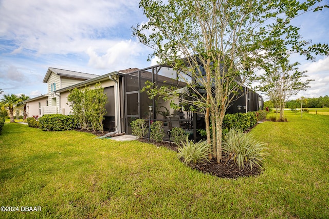 back of house featuring a lanai and a yard