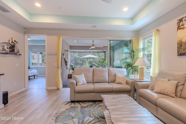 living room featuring light hardwood / wood-style flooring and a tray ceiling