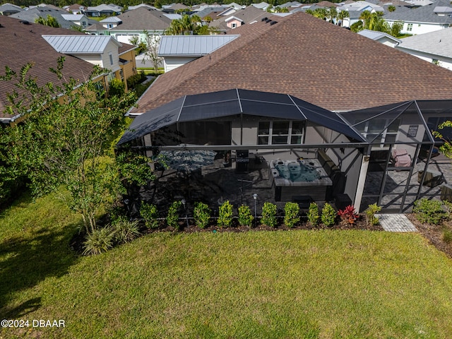 rear view of property featuring a patio area, outdoor lounge area, a yard, and a lanai