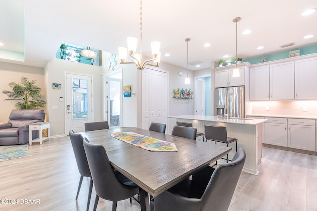 dining room featuring light wood-type flooring and a chandelier