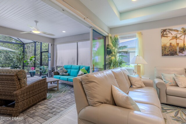 living room featuring light hardwood / wood-style floors, ceiling fan, and a healthy amount of sunlight