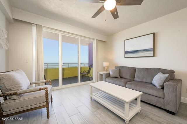 living room featuring light wood-style flooring and ceiling fan