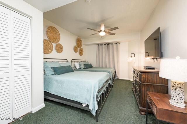 bedroom with baseboards, a closet, dark carpet, and a ceiling fan