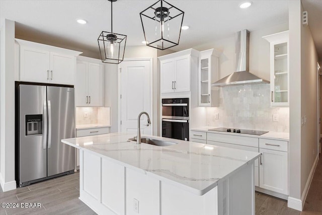 kitchen with white cabinets, wall chimney exhaust hood, and appliances with stainless steel finishes