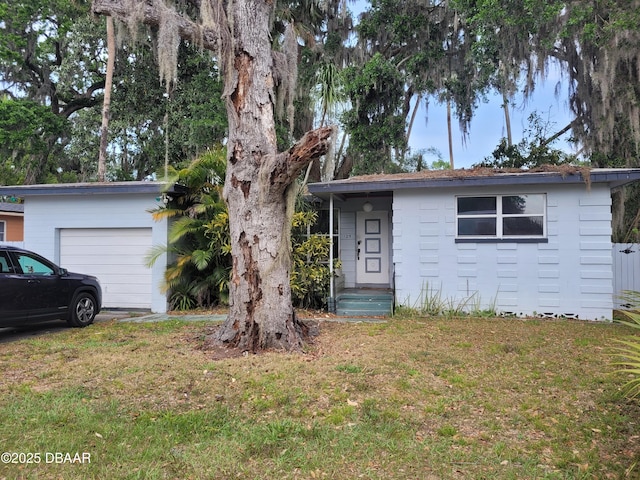 single story home with a garage, an outdoor structure, and a front lawn