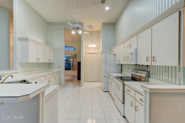 kitchen featuring white cabinetry, sink, white appliances, and kitchen peninsula