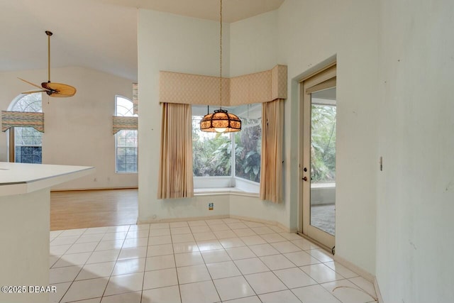 interior space featuring lofted ceiling, light tile patterned floors, and ceiling fan