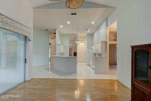 kitchen featuring white cabinetry, hanging light fixtures, light hardwood / wood-style flooring, ceiling fan, and white appliances