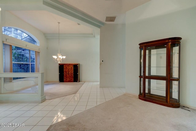 tiled empty room featuring a high ceiling and a notable chandelier