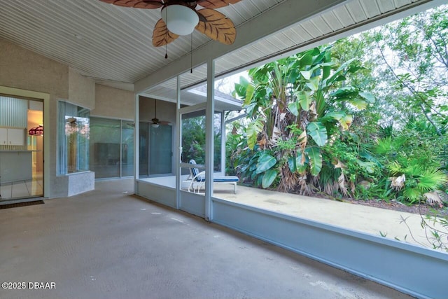 unfurnished sunroom with ceiling fan