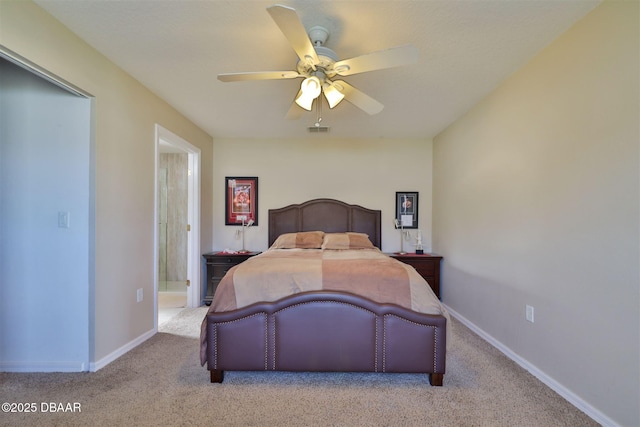 bedroom with light colored carpet, ceiling fan, and ensuite bathroom