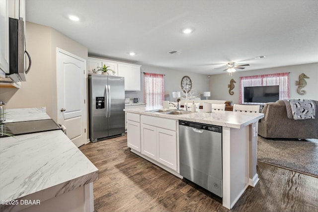 kitchen featuring appliances with stainless steel finishes, sink, a kitchen island with sink, and white cabinets