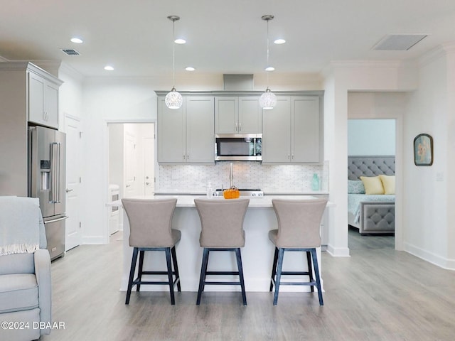 kitchen with light countertops, appliances with stainless steel finishes, visible vents, and light wood-type flooring