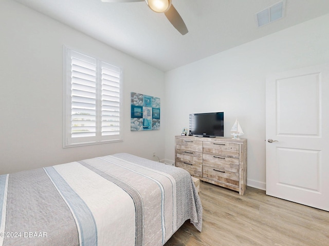 bedroom featuring a ceiling fan, baseboards, visible vents, and light wood-style floors