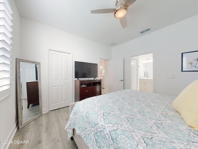 bedroom with ceiling fan, visible vents, wood finished floors, baseboards, and ensuite bath