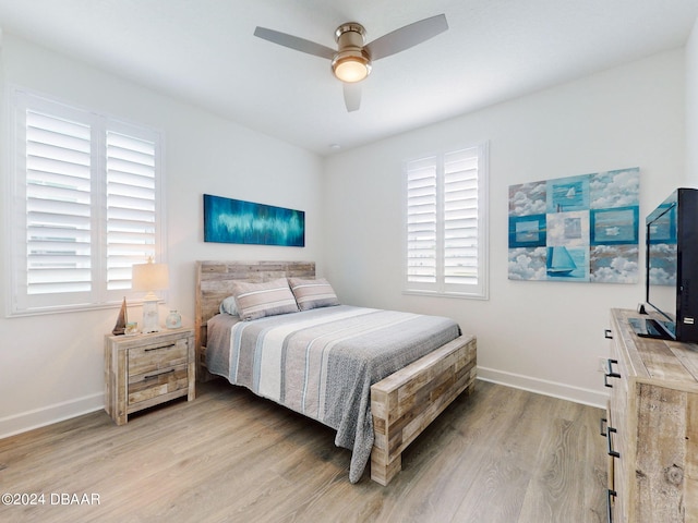 bedroom featuring a ceiling fan, baseboards, and light wood-type flooring