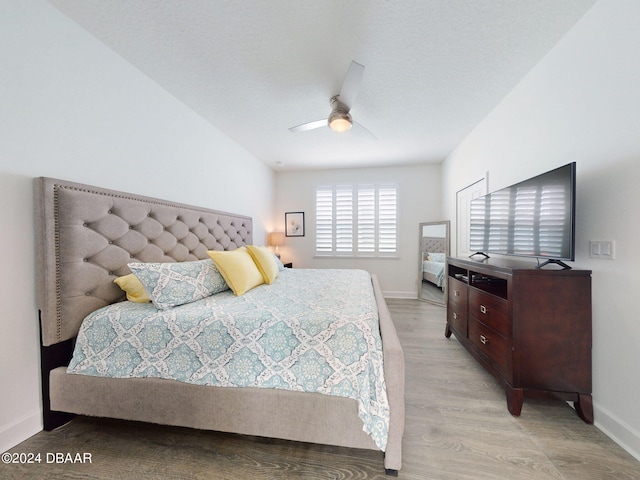 bedroom featuring a ceiling fan, baseboards, and light wood-style flooring