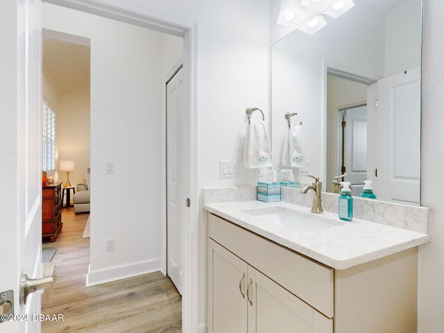 bathroom featuring baseboards, wood finished floors, and vanity