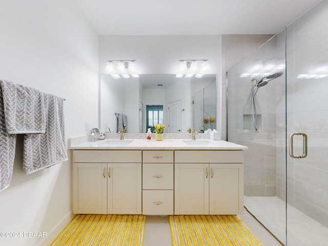 full bath featuring double vanity, a sink, and a stall shower
