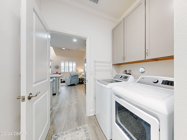 washroom with independent washer and dryer, crown molding, light wood finished floors, and cabinet space