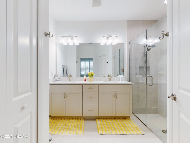 bathroom featuring double vanity, visible vents, tile patterned flooring, a stall shower, and a sink