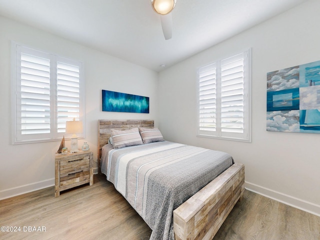 bedroom with baseboards, ceiling fan, and wood finished floors