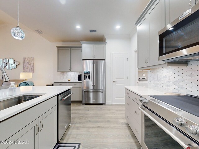 kitchen featuring light countertops, stainless steel appliances, gray cabinetry, and a sink
