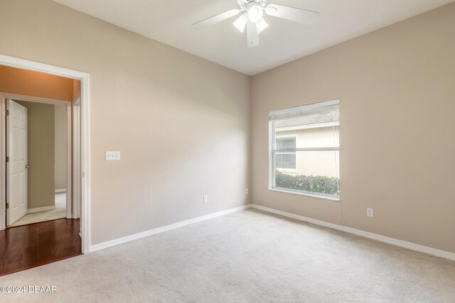 carpeted spare room with ceiling fan