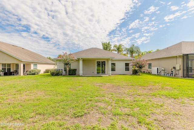 rear view of property featuring a lawn