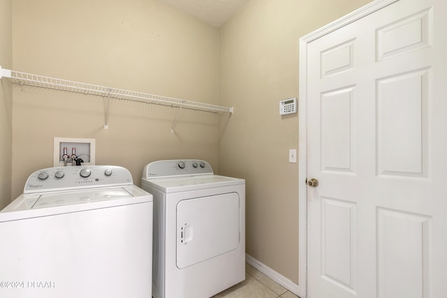 clothes washing area featuring separate washer and dryer and light tile patterned floors