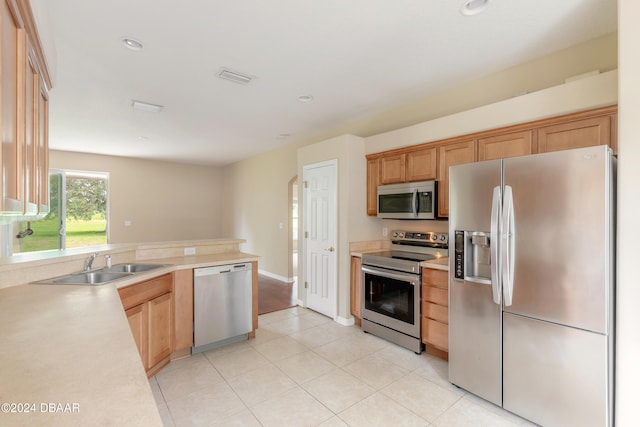 kitchen with sink, light tile patterned floors, and stainless steel appliances