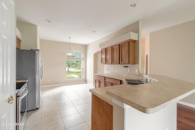 kitchen with stainless steel appliances, light tile patterned floors, hanging light fixtures, sink, and kitchen peninsula