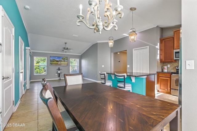 3328 Marsili Ave, New Smyrna Beach, FL 32168 - dining area with ceiling fan with notable chandelier, vaulted ceiling, light tile patterned floors, and crown molding