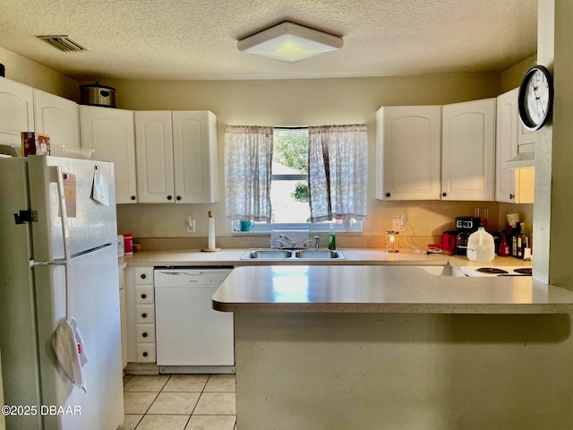 kitchen featuring light tile patterned flooring, sink, kitchen peninsula, white appliances, and white cabinets