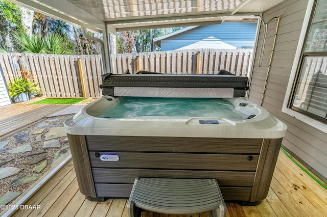 wooden deck featuring a hot tub