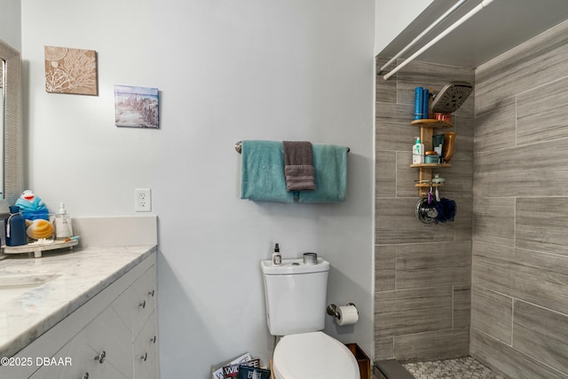 bathroom featuring vanity, toilet, and tiled shower