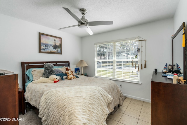 tiled bedroom with ceiling fan and a textured ceiling