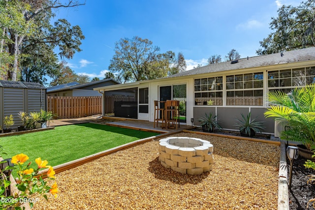 back of property with an outdoor fire pit, a patio, and a shed