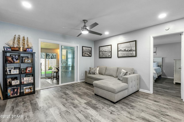 living room featuring wood-type flooring and ceiling fan