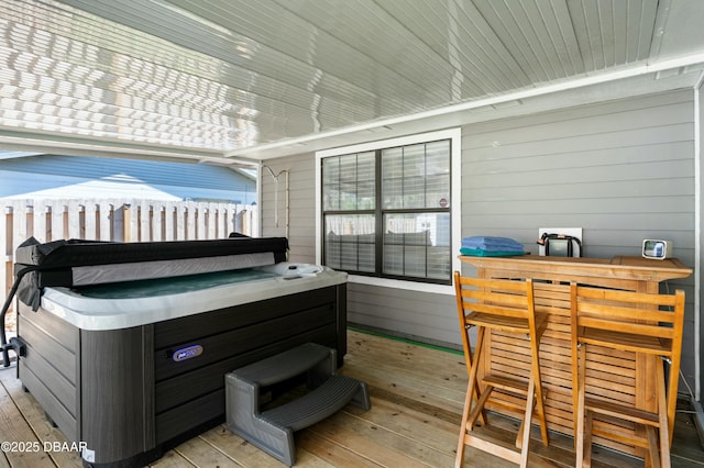 wooden terrace with a hot tub and exterior bar