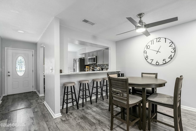 dining space featuring dark wood-type flooring and ceiling fan