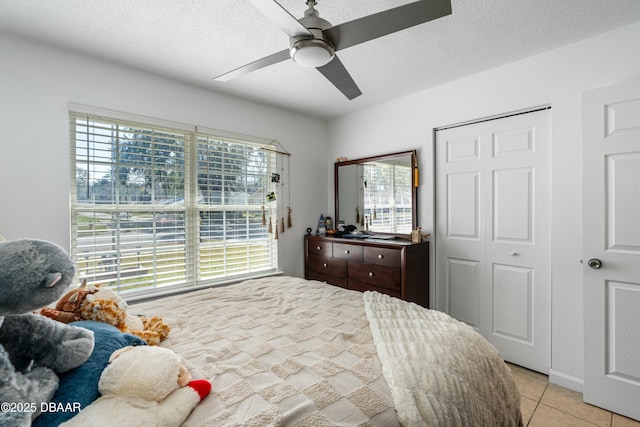 bedroom with light tile patterned flooring, a closet, multiple windows, and a textured ceiling