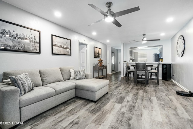 living room featuring ceiling fan and wood-type flooring