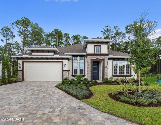 prairie-style home with a front lawn and a garage