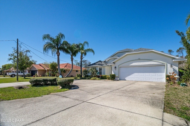 view of front of house featuring concrete driveway, a garage, and stucco siding