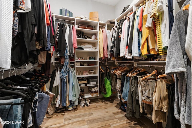 walk in closet with light hardwood / wood-style flooring