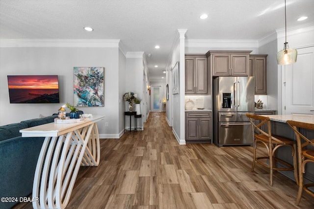 kitchen with high end refrigerator, dark hardwood / wood-style floors, a textured ceiling, and crown molding